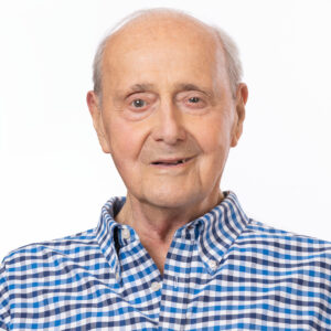 Headshot of Leonard Tow. Leonard is white man in is his 90s, wearing a blue checkered shirt in front of a plain white background.